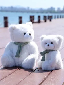 Simpatico orsetto di peluche bianco con sciarpa verde, morbida bambola dettaglio foto