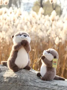 Detailed view of cute praying otter plush toy in natural outdoor setting, soft and cuddly.