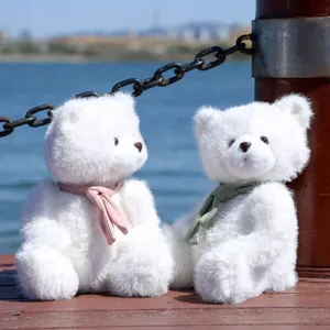 Dettaglio di simpatici orsacchiotti peluche bianchi con sciarpe e morbida pelliccia.