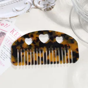 Detail view of the tortoiseshell acetate hair comb featuring cute heart cutouts for daily styling.