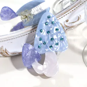 Nahaufnahme einer niedlichen Pilz Haarklammer aus Acetat mit glitzernden blauen Strasssteinen.