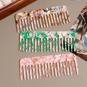 Detailed close-up of wide-tooth hair combs in three marbled acetate colors for daily styling.