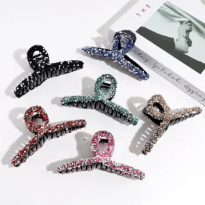 Detail view of elegant rhinestone and pearl hair claw clips, assorted colors for daily use.