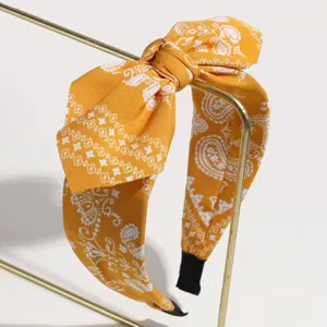 Nahaufnahme des gelben Paisley Haarreifens Stoffdetail, elegantes Schleifen Haaraccessoire.