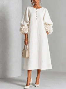 Dettaglio del vestito midi elegante con grandi maniche floreali e delicati bottoni sul collo.