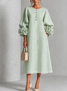 Primo piano dell'elegante abito verde menta con squisiti polsini con fiori 3D e bottoni.