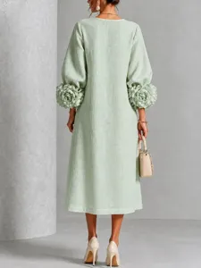 Dettaglio vista posteriore dell'elegante abito midi verde chiaro con maniche floreali uniche.