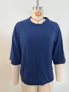 Close-up detail view of women's solid color spliced crew neck three-quarter sleeve t-shirt.