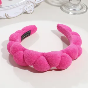 Detail shot of the pink plush braided cloud headband, showing soft texture and unique wavy shape.