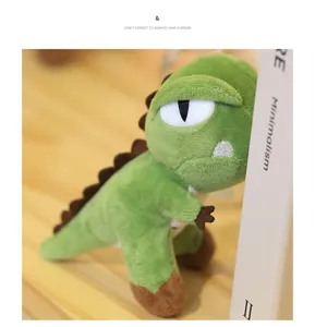 Cute green dinosaur plush toy detail shot, mini stuffed doll ornament for desk decor.