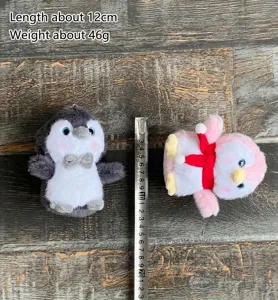 Cute plush penguin keychain detail showing soft fabric, cute eyes, bow tie and scarf.