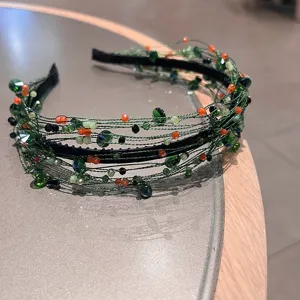 Nahaufnahme des grünen Kristallperlen gedrehten geflochtenen Haarreif Accessoires für Damen.