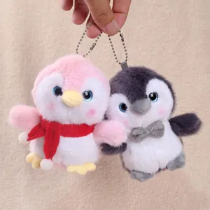 Cute penguin plush keychain pair with scarf and bow, soft stuffed animal bag pendant.