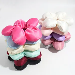 Nahaufnahme von bunten blumenförmigen Satin Haargummis, weiche Stoff Zopfgummis für Frauen.