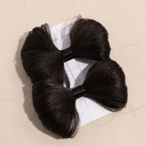 Gros plan de pinces à cheveux nœud marron foncé sur carte montrant la texture synthétique.