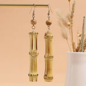 Detailed close-up of handmade bamboo and wooden bead drop earrings, rustic natural aesthetic style.