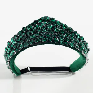 Close-up detail of the retro green crystal crown headband, sparkling rhinestones on soft velvet.