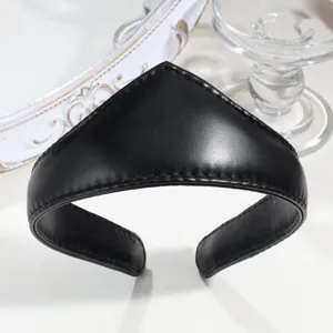 Close-up detail shot of the black leather crown headband, showing smooth texture and pointed design.