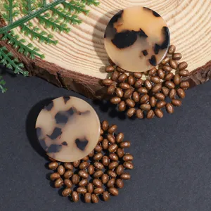 Chic boho earrings featuring round tortoise shell resin pieces and intricate wooden bead drops.