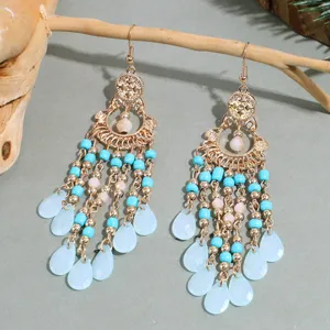 Close-up detail of retro gold-tone turquoise and blue teardrop bead dangle earrings display.