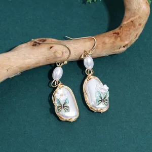 Handcrafted metal pearl butterfly earrings with unique wire-wrapped design, chic fashion jewelry for women.