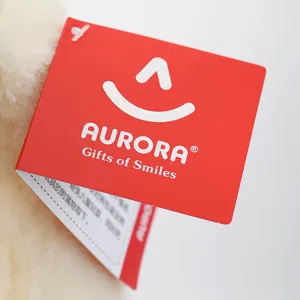 Primer plano de la etiqueta de peluche AURORA que muestra el logo oficial y los detalles.