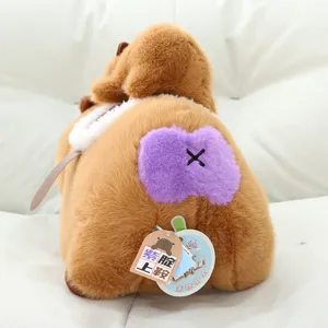 Vista detallada del tierno peluche de capibara suave con pelo marrón y parche morado original.