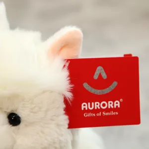 Plush toy detail view showcasing soft white fabric and red brand tag. Cozy and cute close-up.
