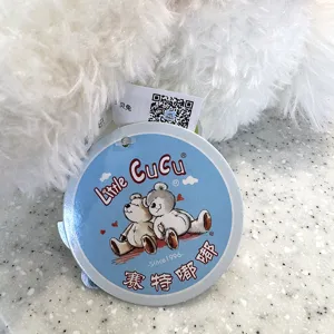 Close-up detail of the plush toy tag showing brand logo and cute bear design, premium quality.