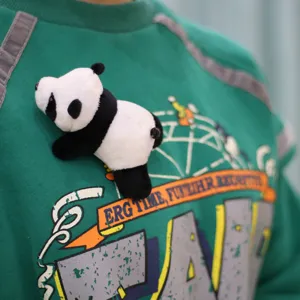 Cute panda plush pendant toy detail shot, soft stuffed giant panda accessory for clothing decoration.