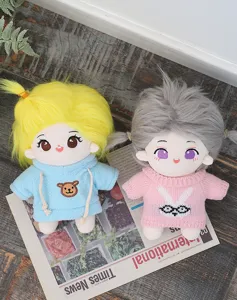 Details von süßen Baumwoll-Plüschpuppen mit bunten Haaren und süßen gestickten Gesichtsausdrücken.