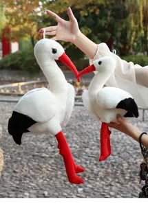 Peluche cicogna vista dettagliata, simpatica bambola di animale imbottito bianco becco rosso.