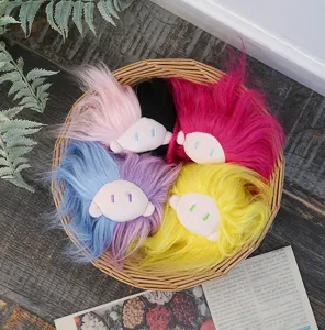 Detailansicht von bunten fluffigen Plüschpuppen Kopfanhängern mit langen Haaren für Taschen.