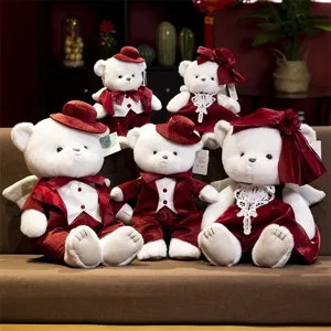 Detail view of cute couple teddy bears plush toys in red formal wear with angel wings.