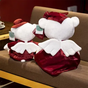 Detailed view of couple angel teddy bear plush toys in red velvet outfits, sitting cozy.