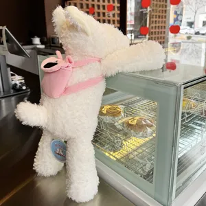 Nahaufnahme des süßen, flauschigen weißen Hund-Plüschtiers mit einem rosa Rucksack im Ladenbereich.