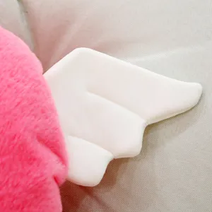 Close-up detail of cute pink plush capybara toy with soft white angel wing design.