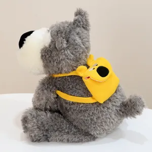 Graues Plüschwelpen-Spielzeug mit gelbem Minirucksack, weiches Stofftier Detailansicht.