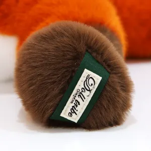 Close-up detail shot of the cute fox plush toy paw, featuring soft faux fur and brand tag.
