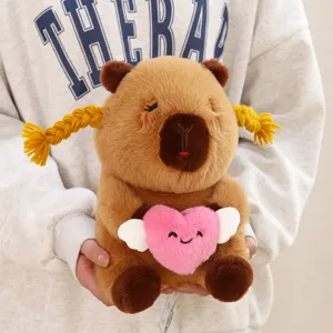 Cute capybara plush toy with yellow braids holding a pink winged heart pillow soft doll.