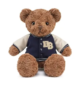 Gros plan détaillé d'un adorable ours en peluche marron portant une veste de baseball.