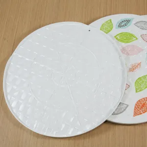 Plateau rond en melamine pour raviolis avec motif de feuilles pour usage domestique.