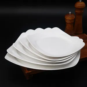 Pile d'assiettes carrées blanches en mélamine pour cantine restaurant et service rapide.