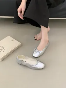 Silberne metallische flache Ballerinas mit runder Kappe, Schleife und Bogenkante.