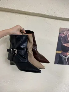 Nahaufnahme von spitzen Keilabsatz Western Stiefeletten in drei Farben mit Seitenschnalle.