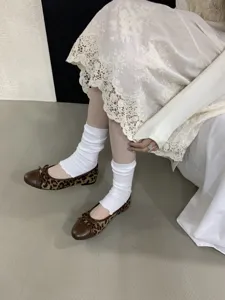 Vista di dettaglio di scarpe basse leopardate da donna con elegante fiocco e punta.