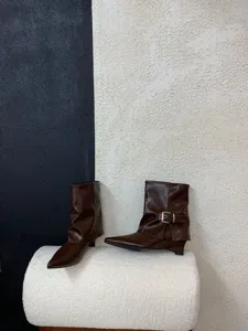 Detailansicht brauner spitzer Keilabsatz Stiefel mit Schnallenriemen, modischer Damenschuh.