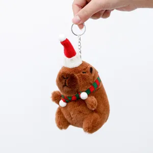 Close-up detail of the cute Christmas capybara plush keychain with a miniature holiday hat.