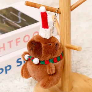 Christmas capybara plush keychain detail shot, cute stuffed animal bag pendant ornament.