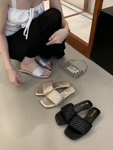 Vista detallada de sandalias planas trenzadas de moda con puntera cuadrada abierta y gran estilo.